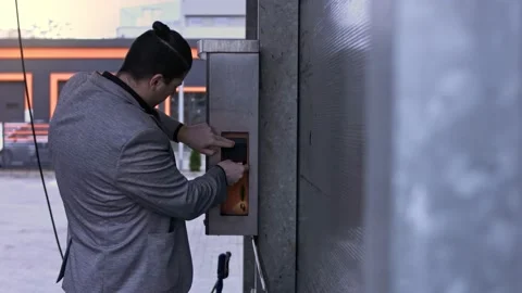 Man on self-service carwash inserts cash for a using on a bill acceptor. 4K Stock Footage 145539617