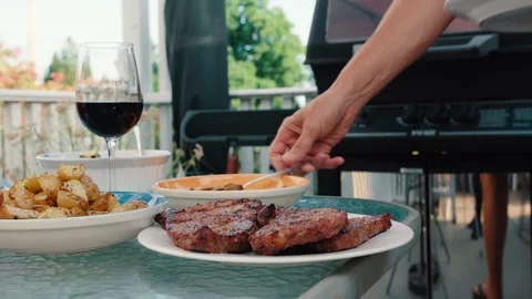 Man Self Serving Steak and Potatoes on a Summer Day in Backyard Stock Footage 92327345