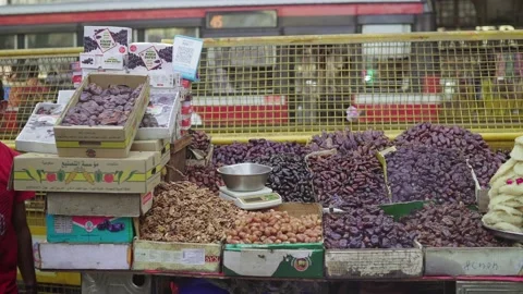 A Man selling Dates or dried fruits on a cart by roadside in metropolitan city. Stock Footage 187960443