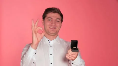 Man Selling Ring To Camera Against Studio Background Vídeos de archivo 141861806