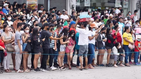Man sells drinks to crowd carrying box on head on street Stock Footage 251497495