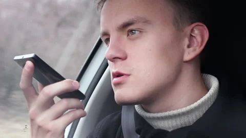 A man sending a audio message with a smartphone in the car Stock Footage 104370052