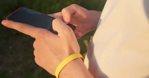 Man sending sms, texting on smartphone in the park Video stock 157651715