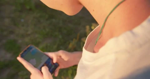 Man sending sms, texting on smartphone in the park Stock Footage 157651763