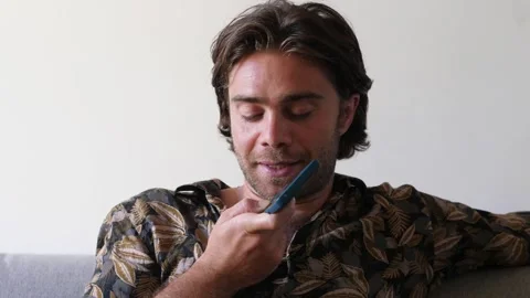 Man sending voice message on sofa Stock Footage 278111041