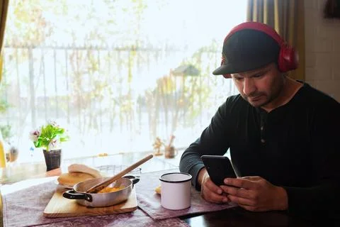Man sends message from cell phone while eating breakfast Stock Photos