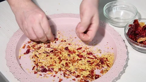 A man separates dry pepper particles from seeds. Prepares seeds for plantin.. Video stock 233200334