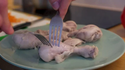 A man separates with a fork the meat from the legs chicken Stock Footage 129058660