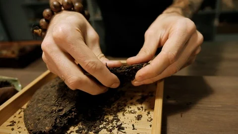 Man separates pieces of pressed tea briquettes closeup Video stock 120664475