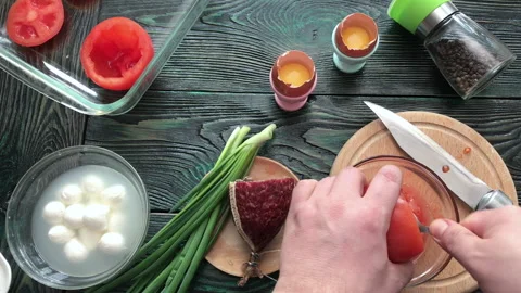 A man separates the pulp from a cut tomato. Makes tomatoes stuffed with che.. Stock Footage 237590433