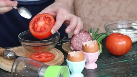 A man separates the pulp from a cut tomato. Makes tomatoes stuffed with che.. Stock Footage 237590435