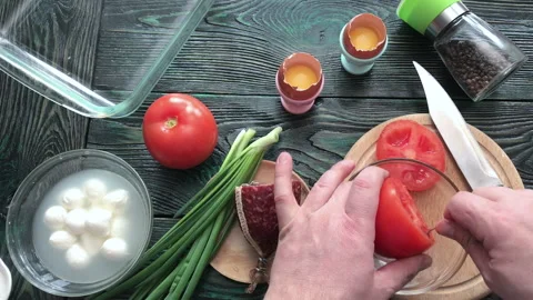 A man separates the pulp from a cut tomato. Makes tomatoes stuffed with che.. Stock Footage 237590540