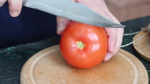 A man separates the pulp with a knife from a cut tomato. Makes tomatoes stu.. Stock Footage 237590529