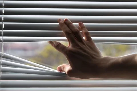 Man separating slats of white blinds indoors, closeup Stock Photos