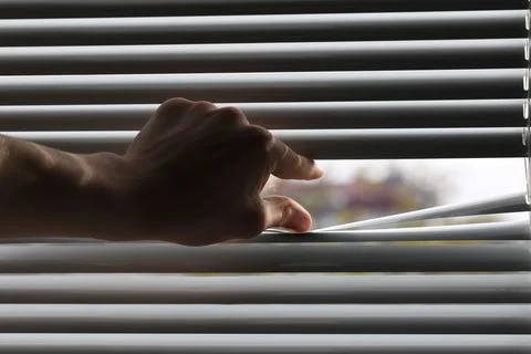 Man separating slats of white blinds indoors, closeup Stock Photos
