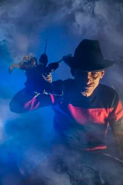 Man is a serial killer with a glove sharp knives background for Halloween Stock Photos
