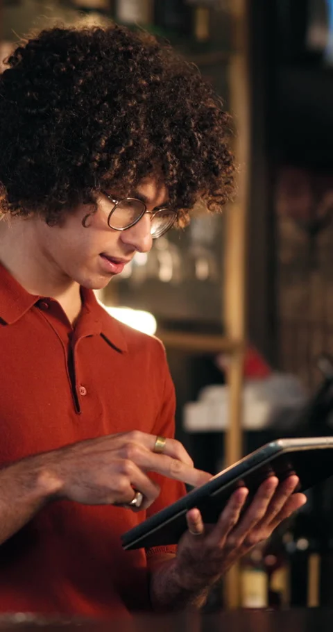 Man, server and reading with tablet at pub for inventory, drinks menu and Stock Footage 329362346