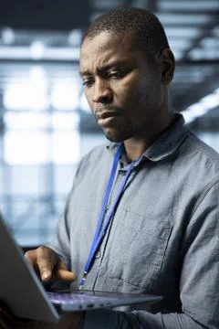 Man in server hub testing failover scenarios using notebook Stock Photos