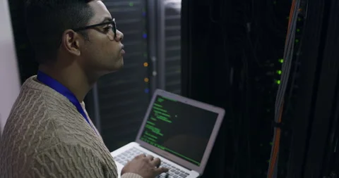 Man in server room with laptop, coding and network administration, engineer in Stock Footage 243021235