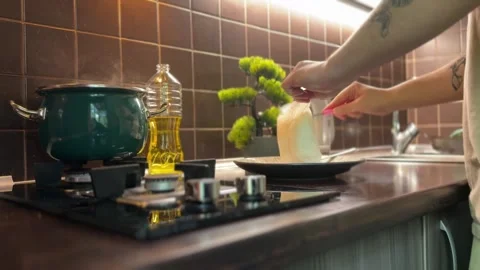 Man Serves Steaming Boiled Bagged Rice Onto a Plate Stock Footage 310503404