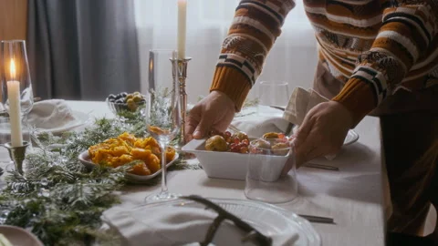 Man Serving Dish on Festive Dining Table, Preparing for Christmas Celebration Stock Footage 292012922