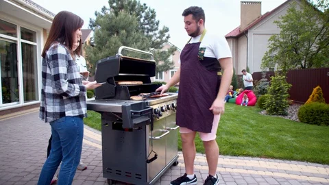 Man serving hot dogs to young women Stock Footage 130066566