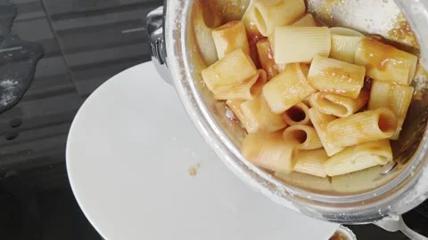Man Serving Pasta with Sauce from Pot to Plate Stock Footage 320396476