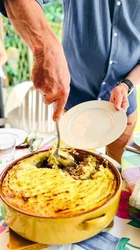 Man Serving a Portion of Hachis Parmentier at the Table Stock-Fotos