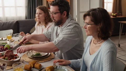Man Serving Roast Meat to Middle Aged Woman during Dinner Stock Footage 340336267