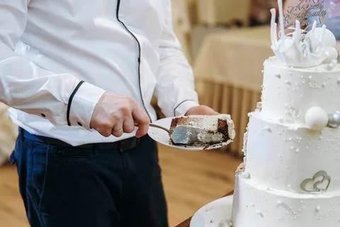 Man serving a slice of delicious layered chocolate and vanilla celebration cake Stock Photos