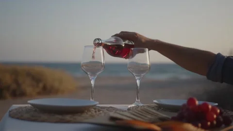 Man serving sparkling wine in glasses on rustic dinner table Stock Footage 270248341
