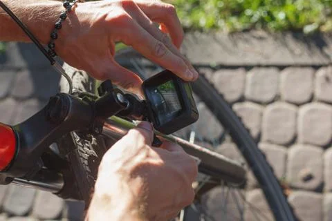 A man sets up an action camera that is fixed next to a bicycle wheel Stock Photos