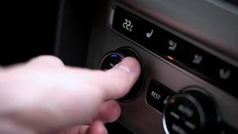 Man sets the air condition temperature in the car Stock Footage 73940785
