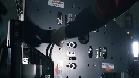 Man sets up automatic cable cutting machine.  Modern Complex for cable cutting Stock Footage 105570932