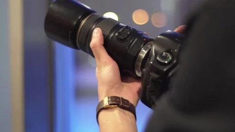 Man sets big lens on a professional DSLR camera Stock Footage 72233408