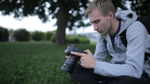 Man Sets Up The Camera Before Shooting Stock Footage 63147790