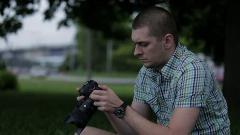 Man sets the camera before taking a picture  Stock Footage 70681382