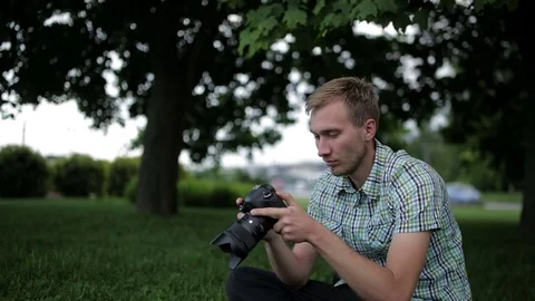 Man sets the camera before taking a picture  Stock Footage 70681489