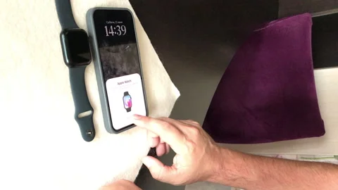 A man sets up the conjugation of smart watches Apple Watch Series 9 with hi.. Stock Footage 279738842