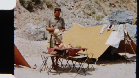 Man Sets Down Beverage At Picnic Table Beside Family Camping Tent Stock Footage 322133613