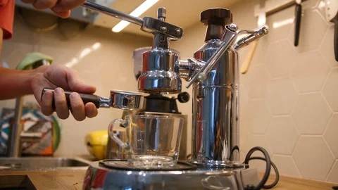 Man sets filte holder in modern steel coffee machine for preparing a cup of Stock Footage 97494256