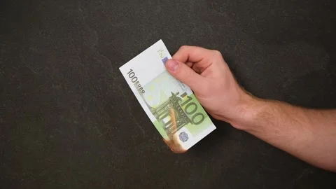 A man sets fire 100 euros. Crisis. Hand holding burning Euro banknotes Stock Footage 242298835