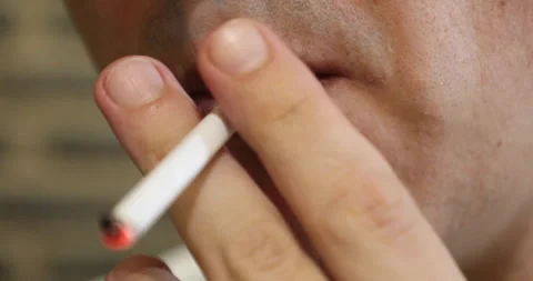 A man sets fire to and smokes a cigarette, close-up Stock Footage 243775254