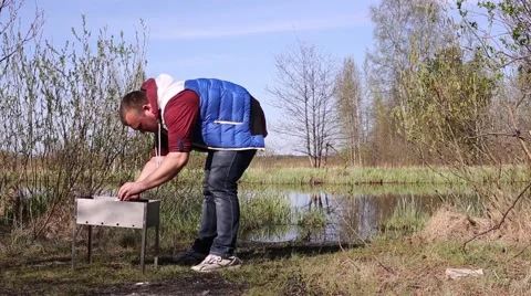 Man Sets Fire to the Coals in the Brazier Stock Footage 63599718