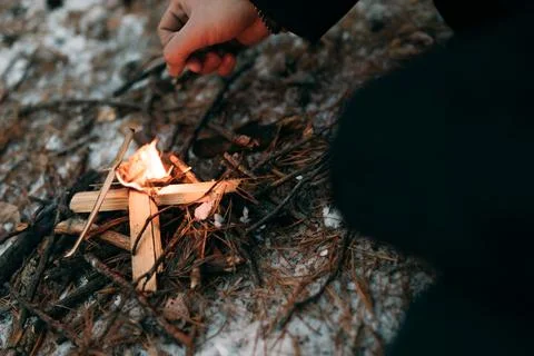 A man sets fire to dry branches in the snow Stock Photos