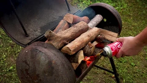 Man sets fire to firewood in the brazier Stock Footage 218973154