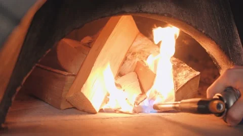 Man sets fire to firewood pile using burner heating stone Video stock 132473923