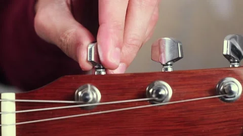 Man Sets up a Guitar. Tuning machine guitar Stock Footage 59728958