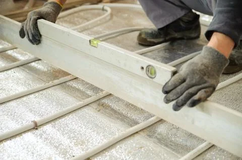 Man sets level concrete floor Stock Photos