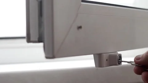 The man sets the lock, protection for children against opening the window Stock Footage 103683836